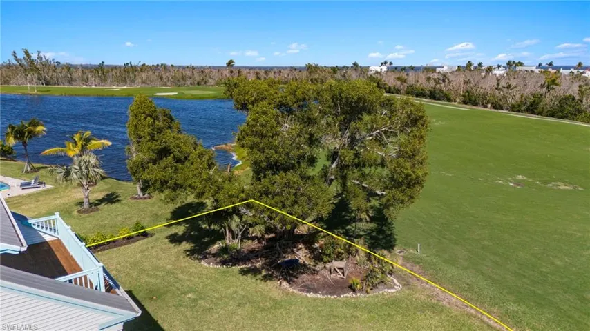 Aerial view of property and surrounding area featuring a nearby body of water and property parcel outlined