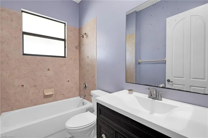 Full bathroom with vanity, toilet, and tiled shower / bath