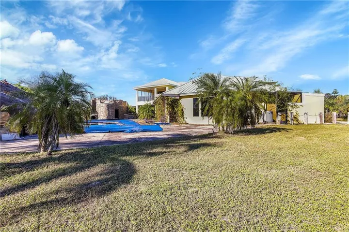 Rear view of house with a yard and a covered pool