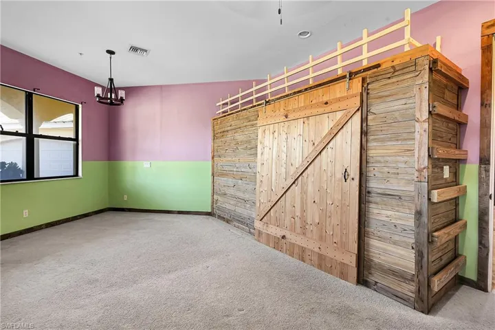 Empty room featuring carpet flooring and a barn door