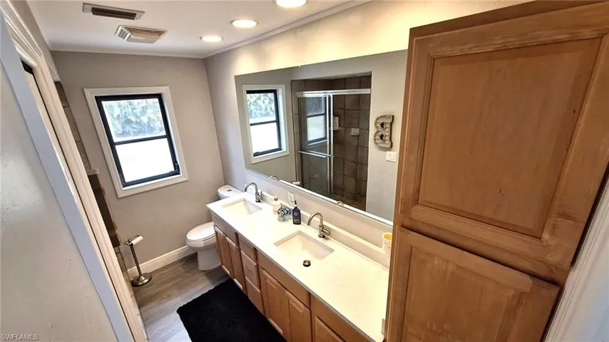 1st Floor master Bathroom with visible vents, a shower stall, vanity, baseboards, and toilet