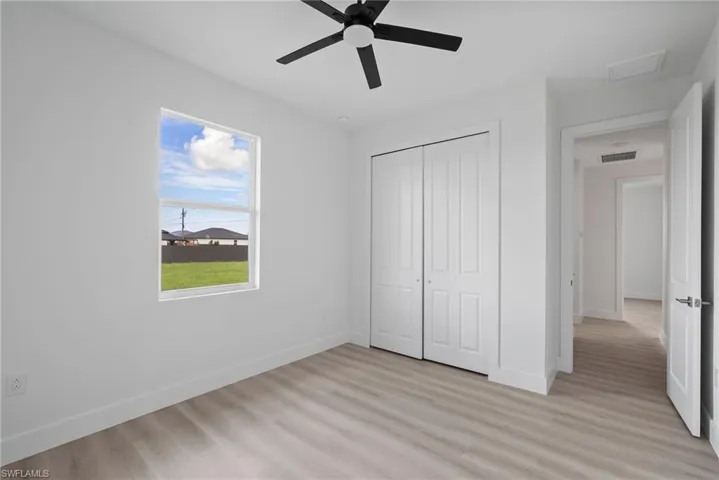Unfurnished bedroom with a closet, ceiling fan, and light wood-type flooring