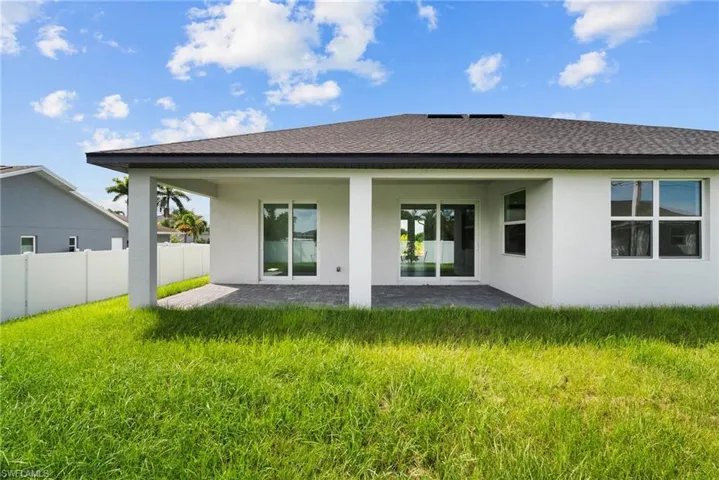 Rear view of house featuring a yard and a patio