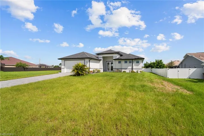 View of front facade with a garage and a front lawn