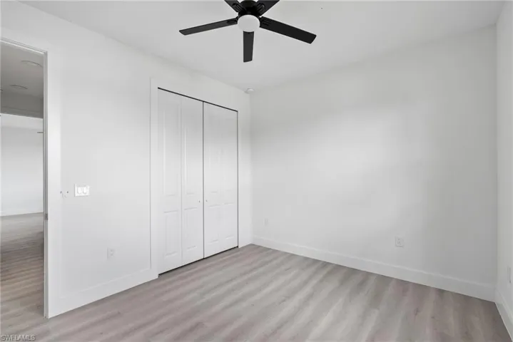 Unfurnished bedroom with ceiling fan, a closet, and light hardwood / wood-style floors
