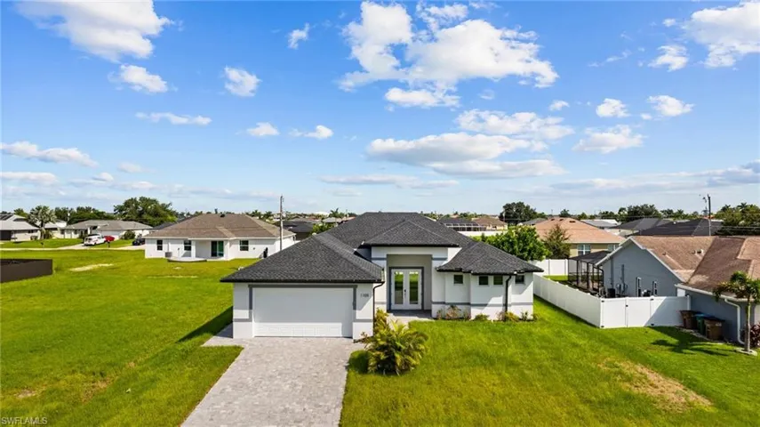 View of front of home with a garage and a front lawn