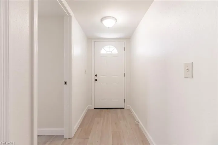 Doorway with light hardwood / wood-style flooring