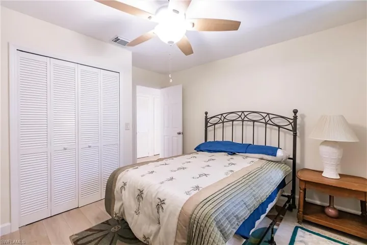 Bedroom with ceiling fan, light hardwood / wood-style floors, and a closet
