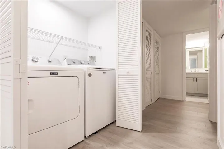 Laundry room featuring light hardwood / wood-style floors and washing machine and clothes dryer