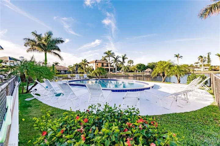 View of swimming pool with a patio area, a yard, and a water view