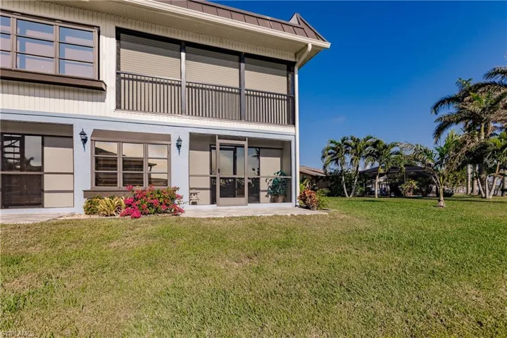 Back of property featuring a lawn