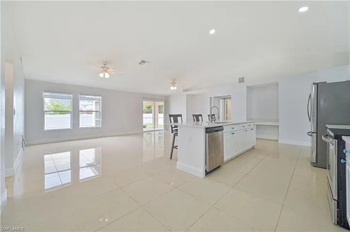 Kitchen featuring ceiling fan, a healthy amount of sunlight, stainless steel appliances, and light tile floors