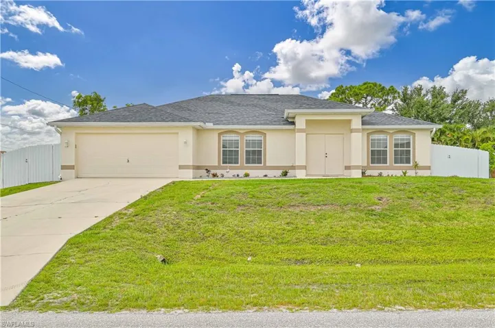 View of front facade with a garage and a front lawn