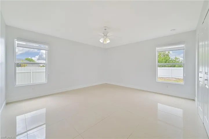 Tiled Master bedroom featuring ceiling fan