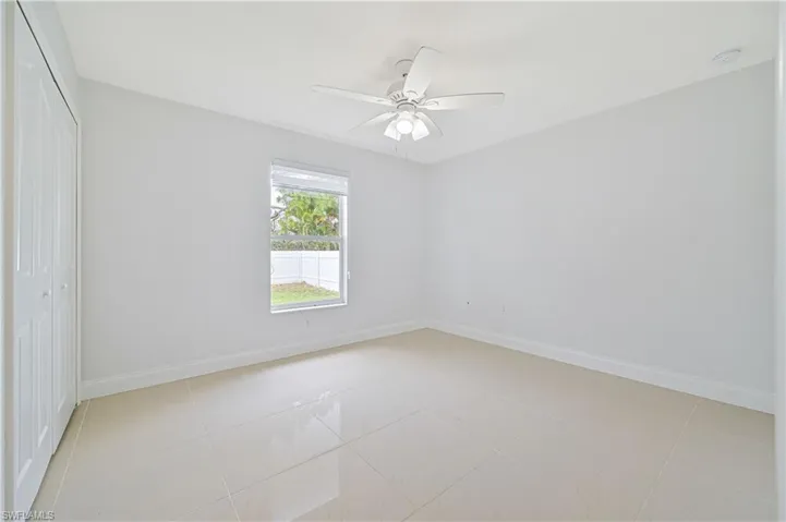 Unfurnished room featuring ceiling fan and light tile floors