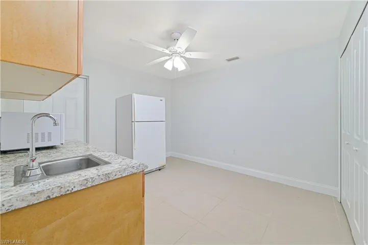 3rd Bedroom appliances, sink, ceiling fan, and light tile floors