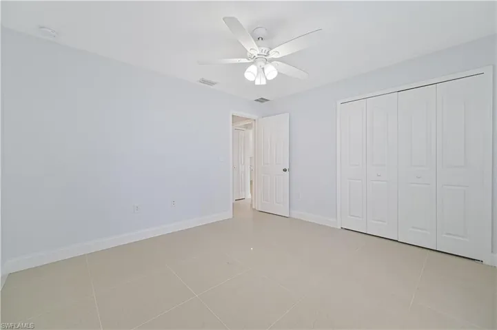 Unfurnished bedroom featuring a closet, ceiling fan, and light tile floors