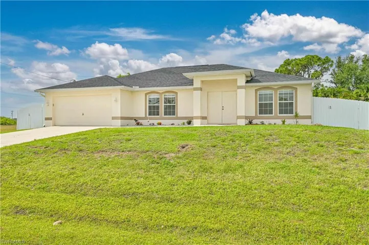 View of front of home featuring a garage and a front yard