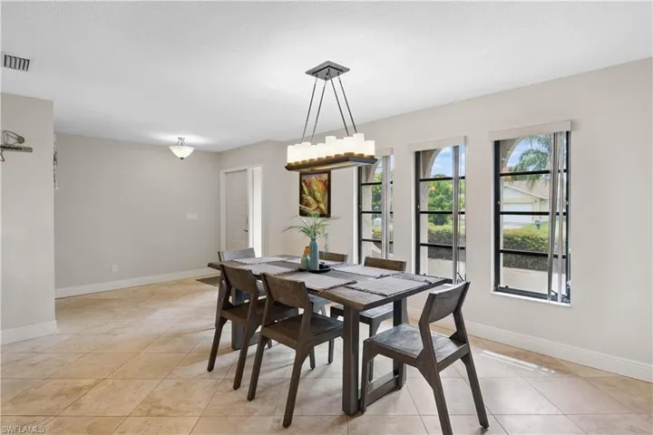 Dining area featuring light tile patterned floors and a chandelier