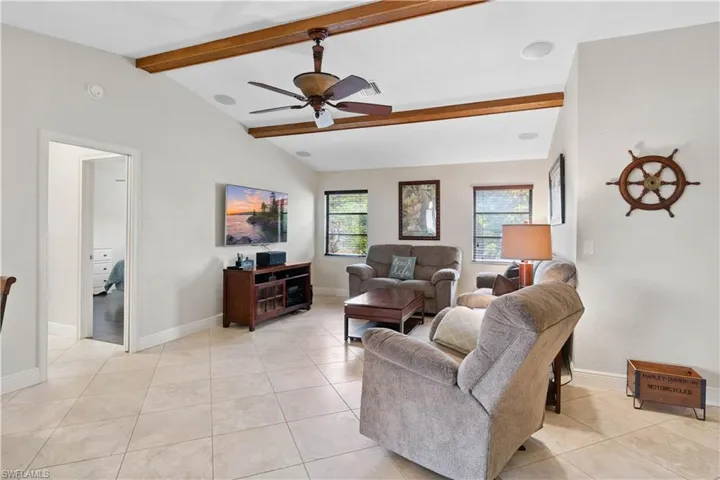 Living area featuring a ceiling fan and light tile patterned floors