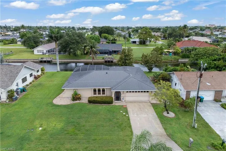 Aerial perspective of suburban area featuring a nearby body of water
