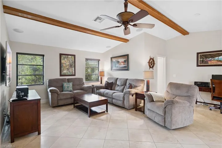 Living room with plenty of natural light, ceiling fan, and light tile patterned flooring