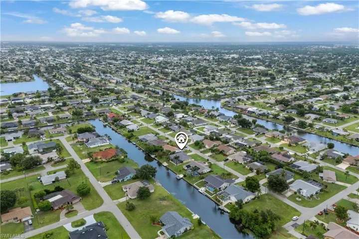 Aerial view of property and surrounding area with nearby suburban area and a large body of water
