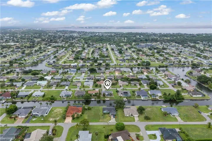 Aerial view of property and surrounding area featuring nearby suburban area