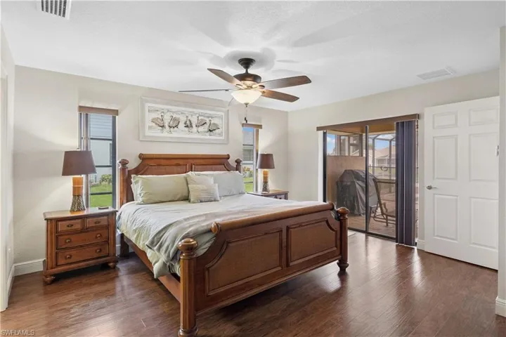 Bedroom featuring access to outside, multiple windows, and dark wood finished floors