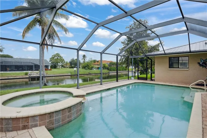 View of pool with a water view, a pool with connected hot tub, and a lanai