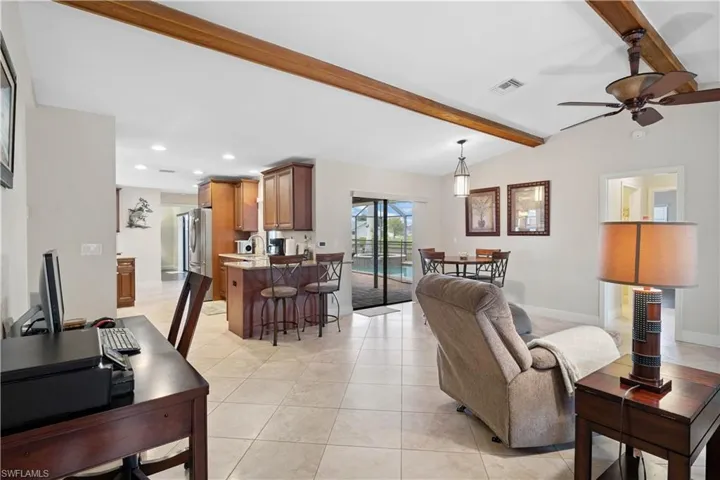 Living area with a ceiling fan, light tile patterned floors, and recessed lighting