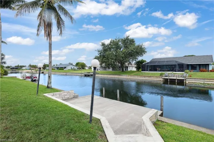 Dock area featuring a water view, a yard, and a residential view