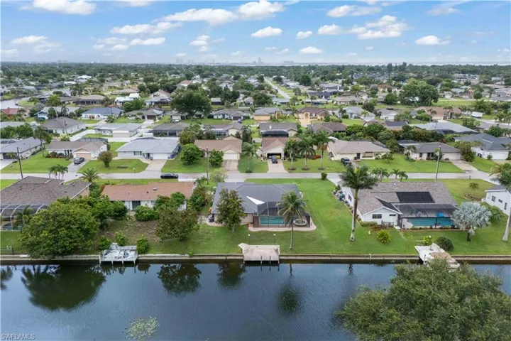 Aerial view of property's location featuring a large body of water and nearby suburban area