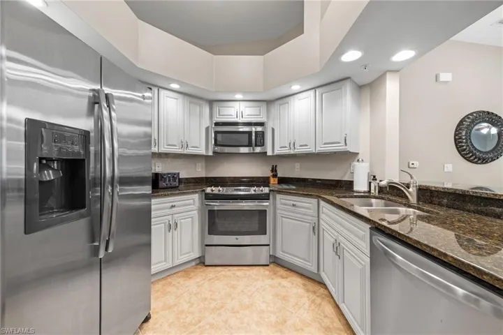 Kitchen with White Wood Cabinetry, Granite Countertops & Stainless Steel Appliances