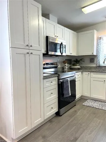SPACIOUS KITCHEN WITH LUXURY VINYL PLANK FLOORING, WHITE SHAKER CABINETS WITH SOFT CLOSE DOORS & GRANITE COUNTERTOPS, BRILLIANT STAINLESS APPLIANCES. REFRIGERATOR OFFERS FILTERED WATER/ICE ON THE DOOR. LARGE PANTRY AND A DOUBLE STAINLESS SINK WITH WINDOW VIEW OF THE FRONT YARD TO ENJOY THE PLANTS, BIRDS, BUNNIES.