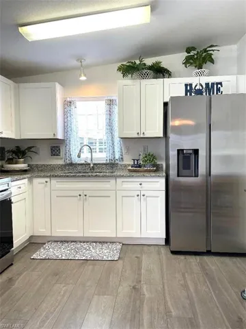 SPACIOUS KITCHEN WITH LUXURY VINYL PLANK FLOORING, WHITE SHAKER CABINETS WITH SOFT CLOSE DOORS & GRANITE COUNTERTOPS, BRILLIANT STAINLESS APPLIANCES. REFRIGERATOR OFFERS FILTERED WATER/ICE ON THE DOOR. LARGE PANTRY AND A DOUBLE STAINLESS SINK WITH WINDOW VIEW OF THE FRONT YARD TO ENJOY THE PLANTS, BIRDS, BUNNIES.