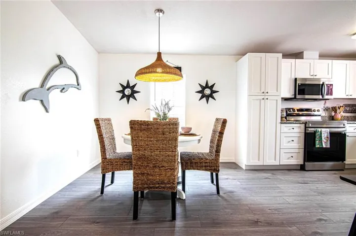 DINING ROOM TO KITCHEN WITH NEW STAINLESS APPLIANCES. REFRIGERATOR WITH FILTERED WATER AND ICE ON THE DOOR. NEW SHAKER CABINETS WITH SOFT CLOSE DOORS AND NEW LUXURY VINYL PLANK FLOORING. VAULTED CEILINGS. REMODELED FROM CEILING DOWN.