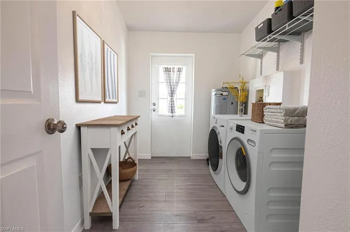 LARGE LAUNDRY ROOM WITH ADJUSTABLE SHELVING AND THE BACK DOOR.