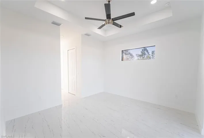 Empty room with a tray ceiling and ceiling fan