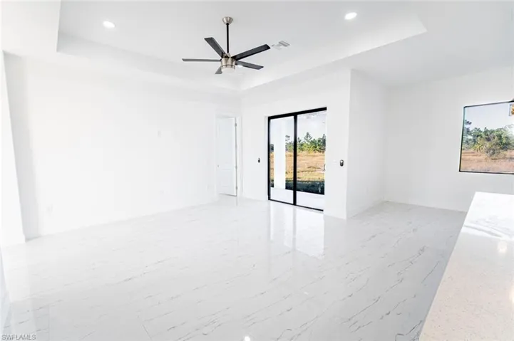 Unfurnished room with a raised ceiling and ceiling fan