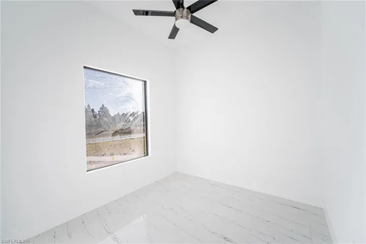 Spare room featuring lofted ceiling and ceiling fan