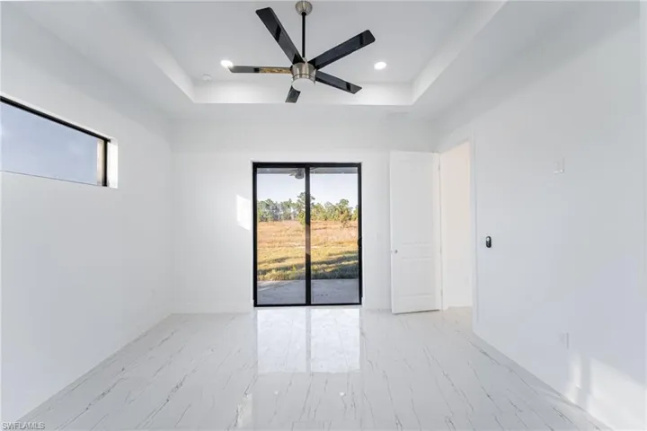 Empty room with a raised ceiling and ceiling fan