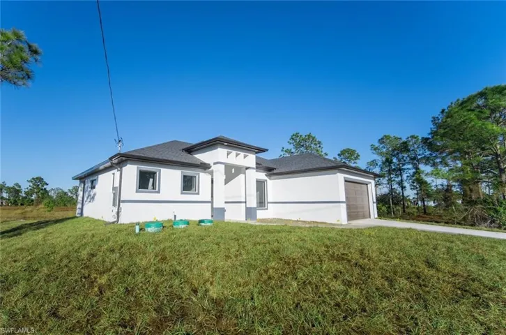 View of front of house with a garage and a front lawn