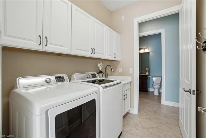 Dedicated laundry room with built-in cabinetry and storage