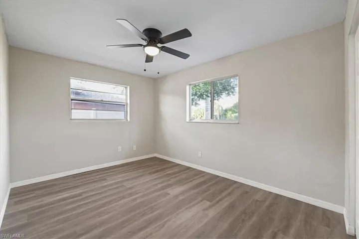 Empty room with wood finished floors and a ceiling fan