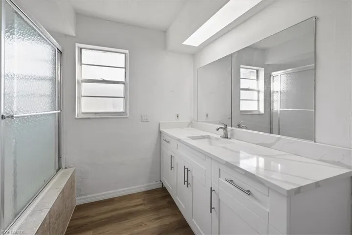 Full bath featuring dark wood-style flooring and vanity