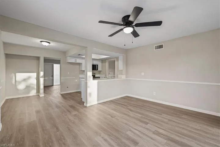 Unfurnished living room with light wood finished floors and ceiling fan