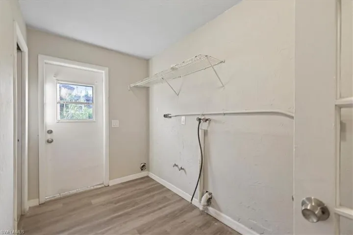 Laundry area with light wood-style flooring and washer hookup