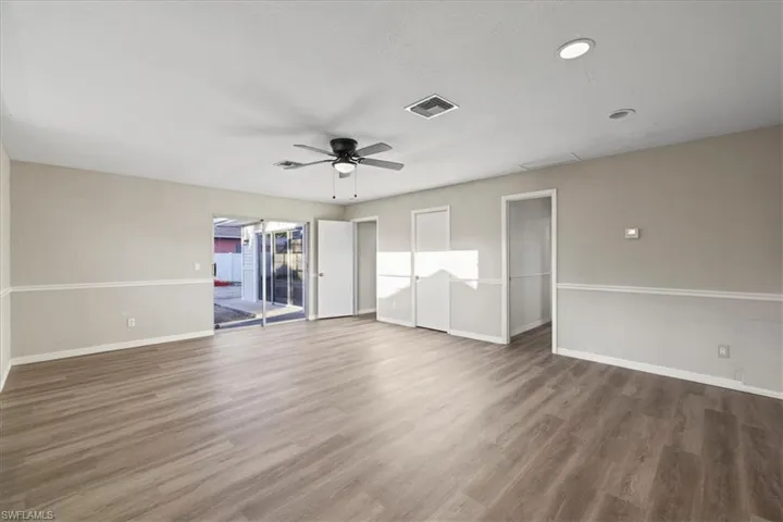 Empty room with wood finished floors and a ceiling fan
