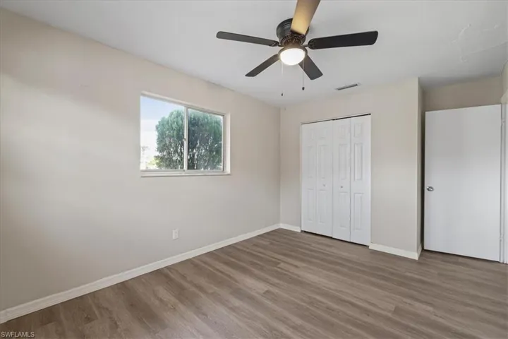 Unfurnished bedroom with wood finished floors, a closet, and ceiling fan